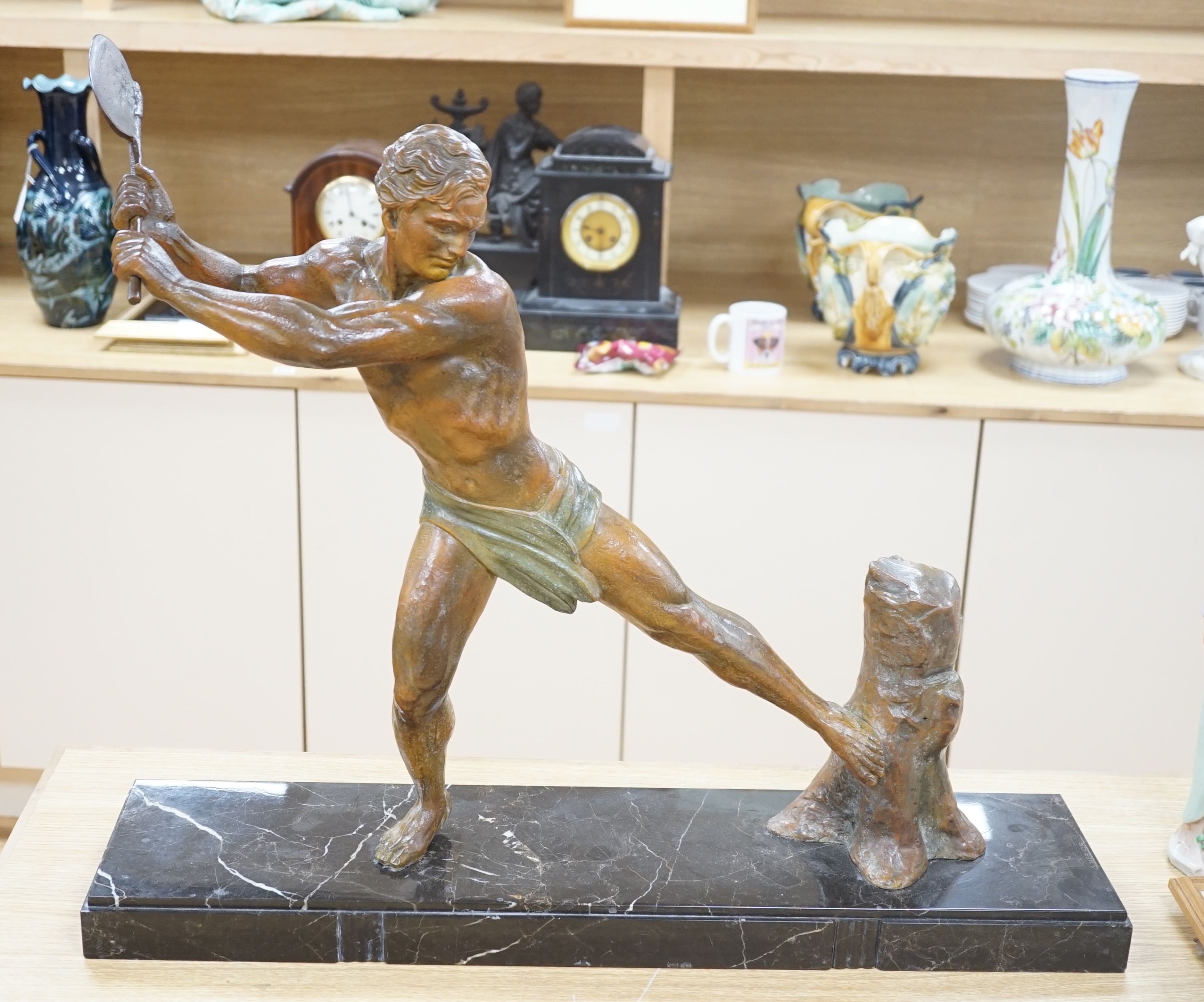 An Art Deco patinated spelter figure of a woodcutter, signed G Hervore, 75cm long